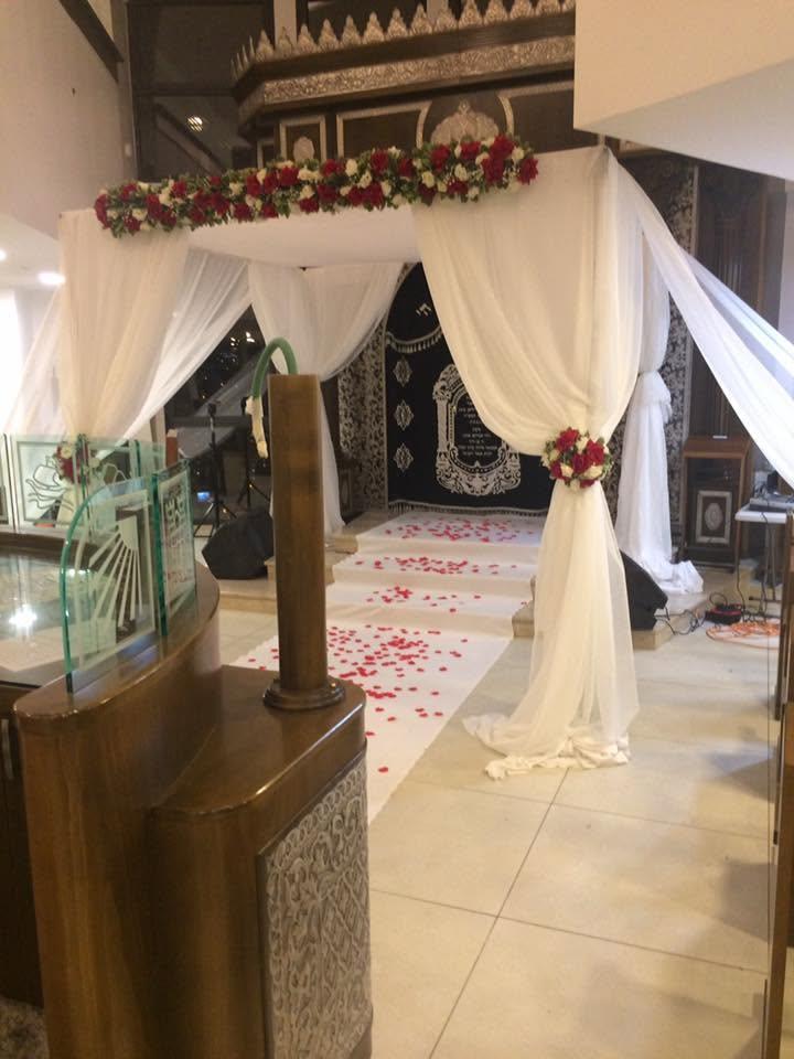Allée de pétales de roses menant à la houppa