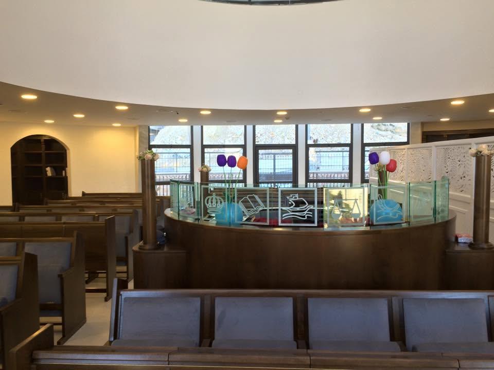 La téba fleurie devant les grandes baies vitrées de la synagogue